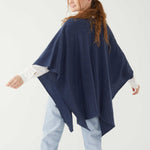 Female wearing a blue wrap over a white button shirt in front of white background