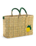 medium sized straw basket with handwoven lemon and green leather handles on a white background