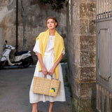 female holding medium sized straw basket with handwoven lemon standing in the street