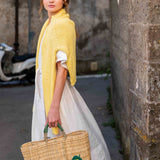 female holding medium sized straw basket with handwoven lemon walking in the street