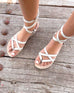 female wearing white leather strappy gladiator sandal standing on a wooden floor 