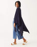 female wearing navy cable knit wrap over her shoulders turned to the side on a white background