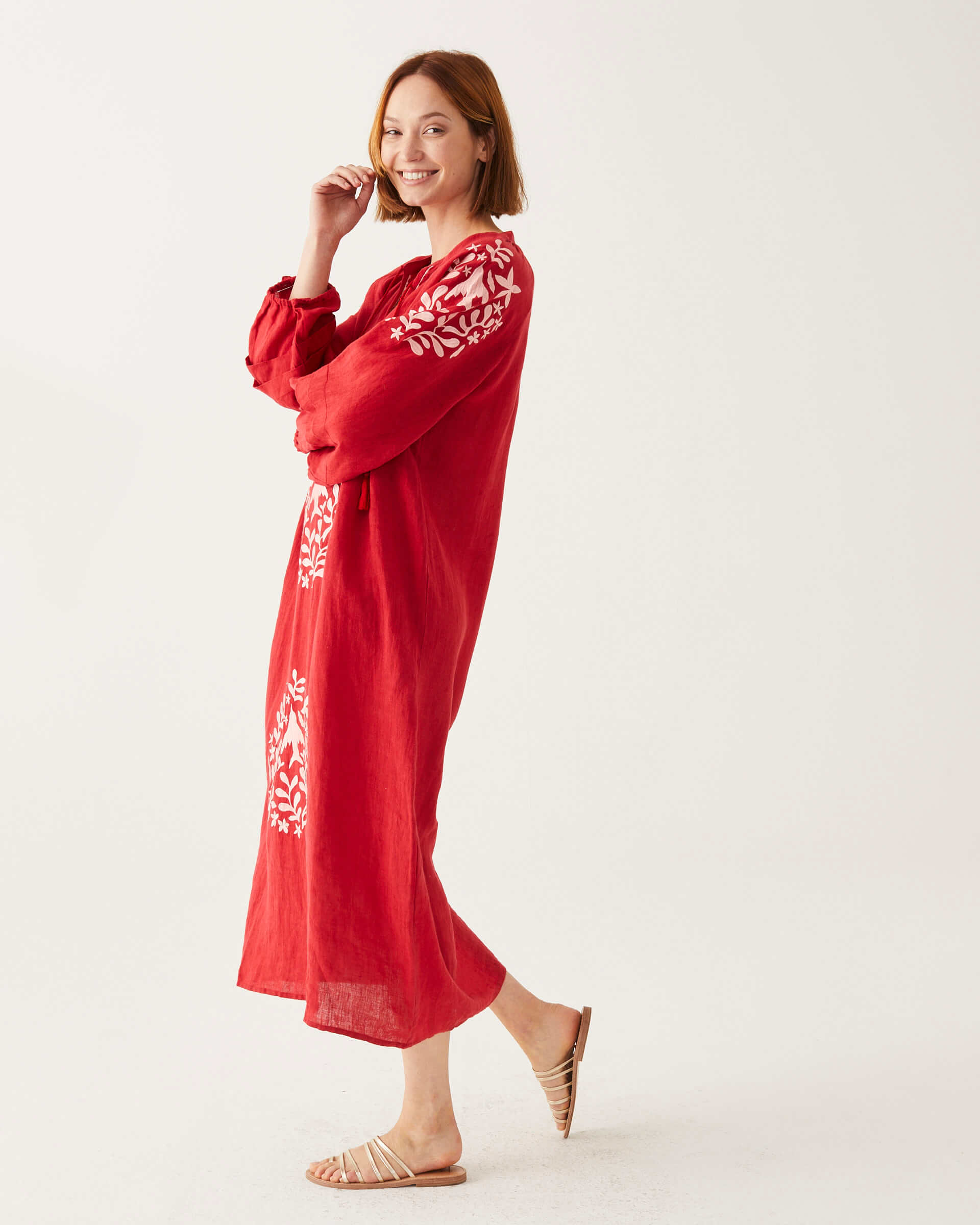 female wearing red and white embroidered maxi dress with tassel ties on a white background