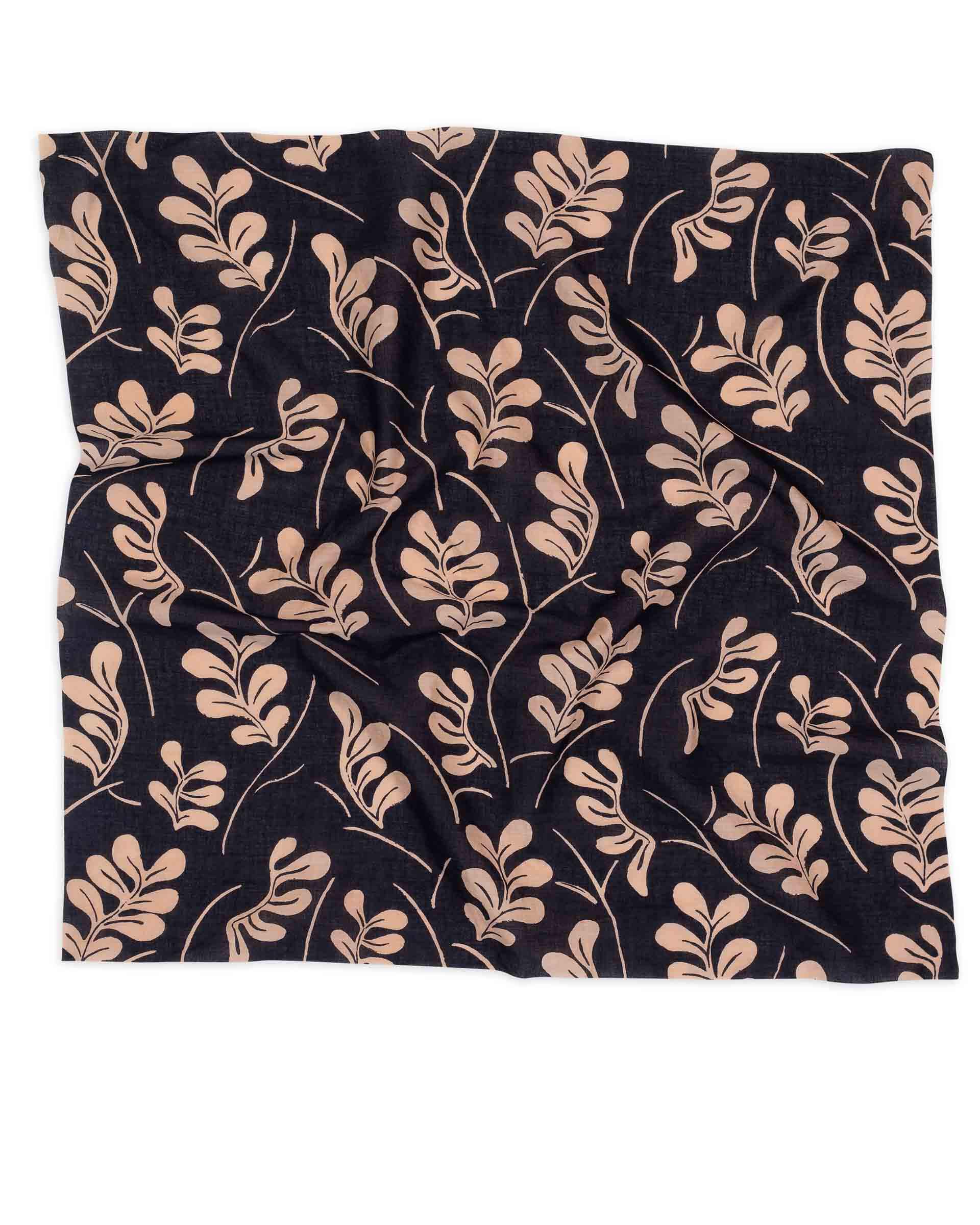 black scarf with brown vine pattern laying on a white background