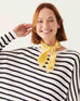 female wearing striped sweater with a yellow striped scarf around her neck on a white background