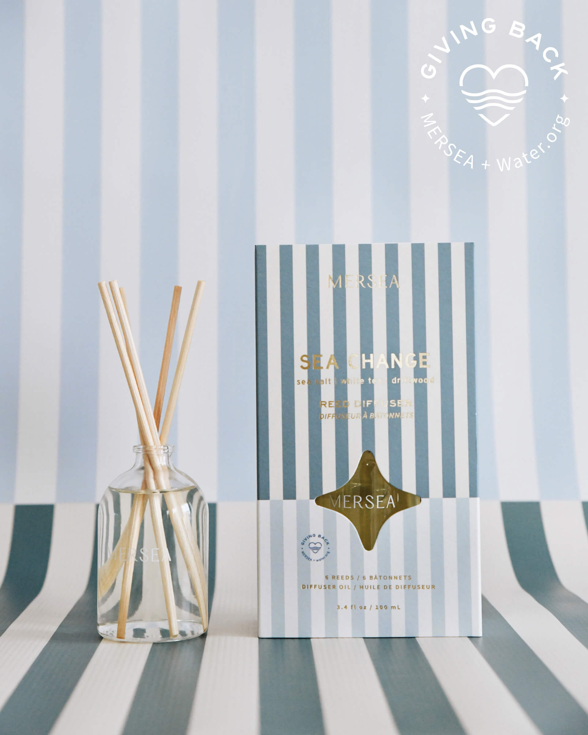 sea change reed diffuser boxed in light and dark blue stripes on light and blue striped background 