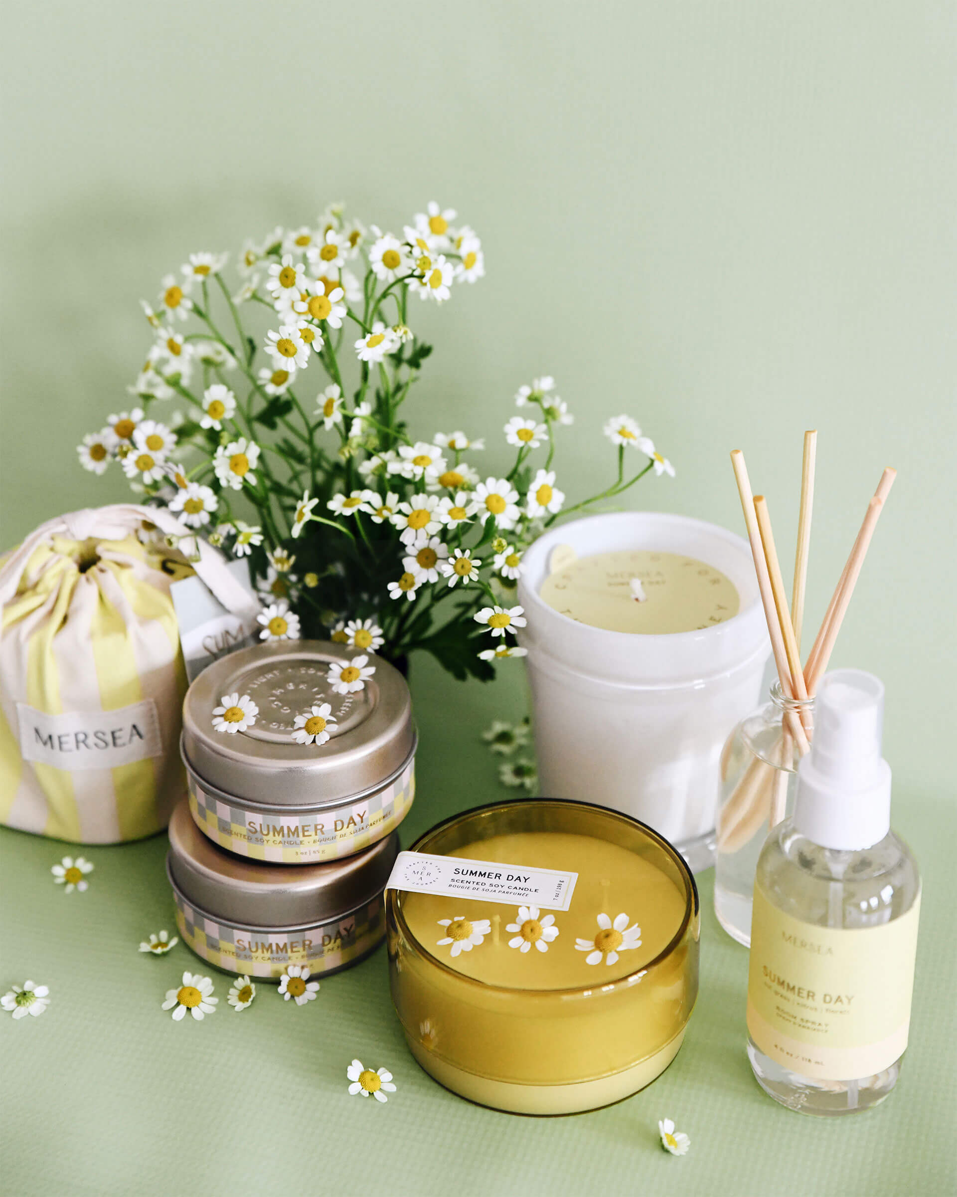 Summer Day product collection of candles, room sprays and diffusers in front of yellow background