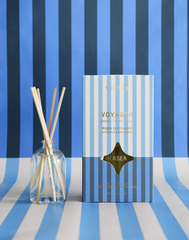 voyager reed diffuser boxed in light and dark blue stripes on light and blue striped background 